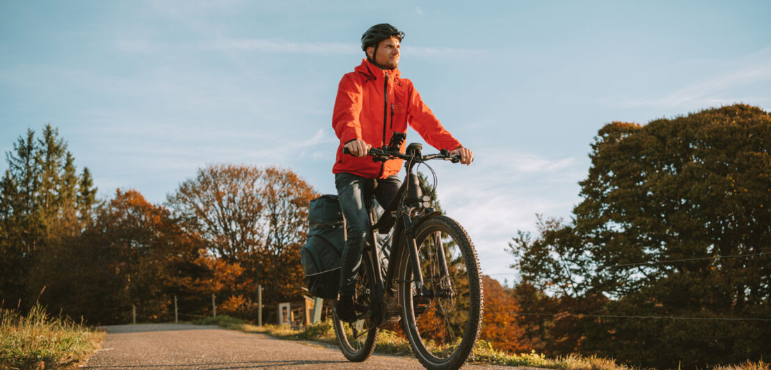 Eine Person radelt mit ihrem Fahrrad durch die Natur