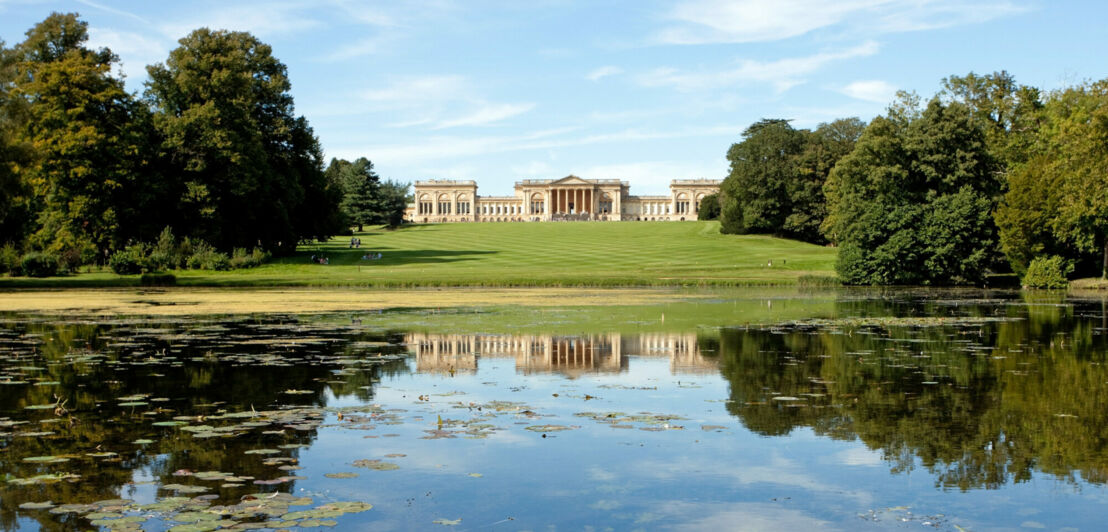 Außenansicht des Stowe House, das inmitten einer großen Grünanlage mit See liegt