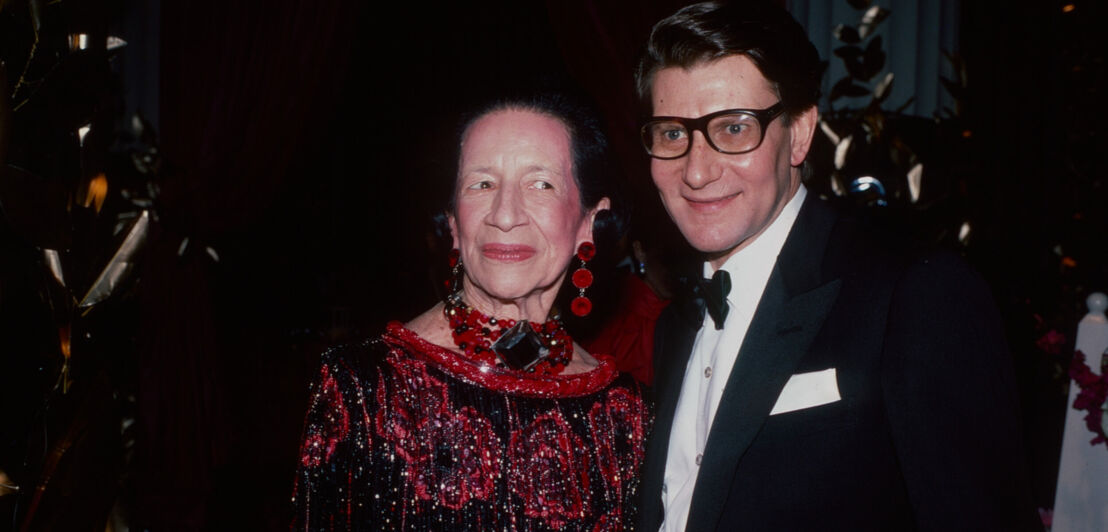 Diana Vreeland in rotem Abendkleid und Yves Saint Laurent im Anzug auf der Met Gala.