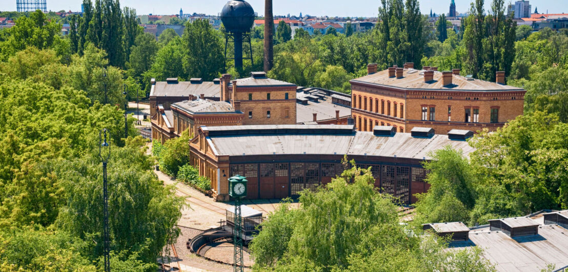 Begrünter Museumspark auf einem alten Bahngelände mit Ringlokschuppen