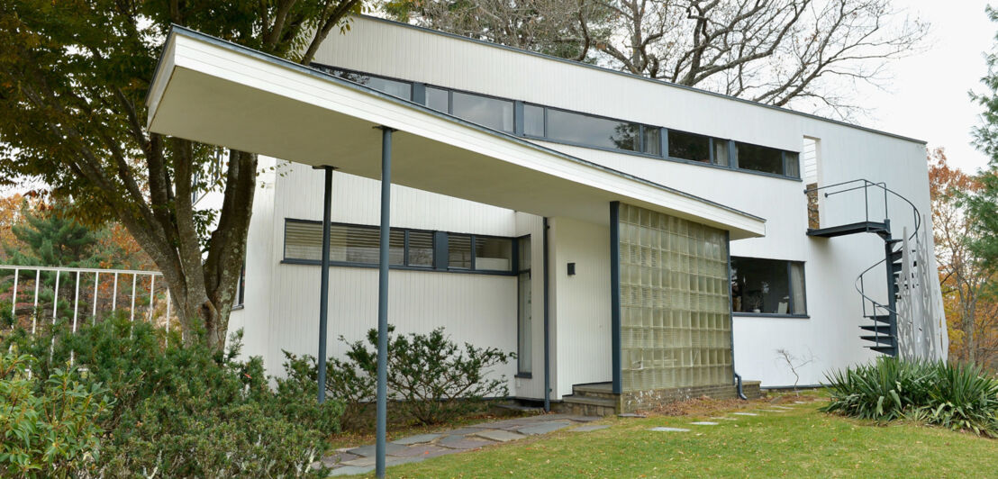 Ein weißes Wohnhaus im Bauhaus-Stil mit Garten