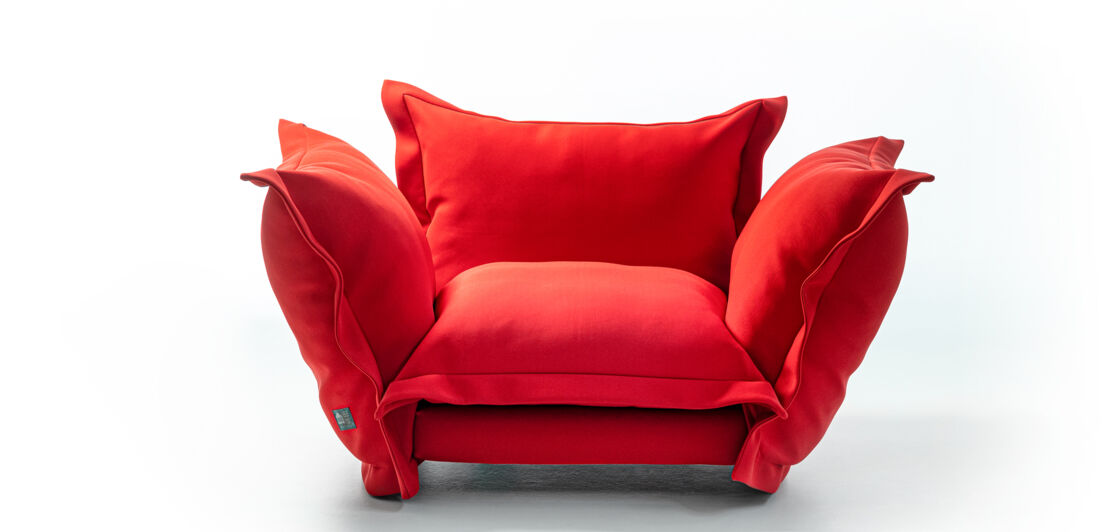 Tomatenrotes Sofa von Moroso mit großen, weichen Kissen.