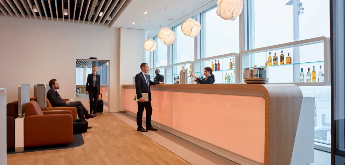 Personen an einer Bar in einer Lufthansa Flughafenlounge