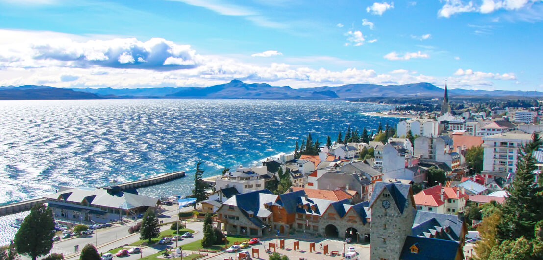 Stadtpanorama von Bariloche an einem Gletschersee mit Bergen im Hintergrund