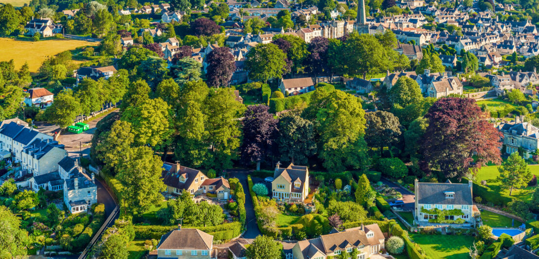 Panorama-Luftaufnahme einer malerischen Landschaft mit Landhäusern umgeben von grünen Hügeln