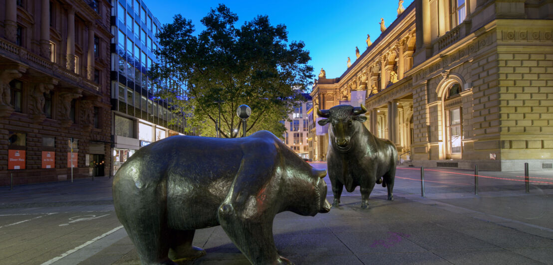 Zwei Bronzestatuen in Stier- und Bärengestalt vor dem Gebäude der Frankfurter Börse bei Nacht