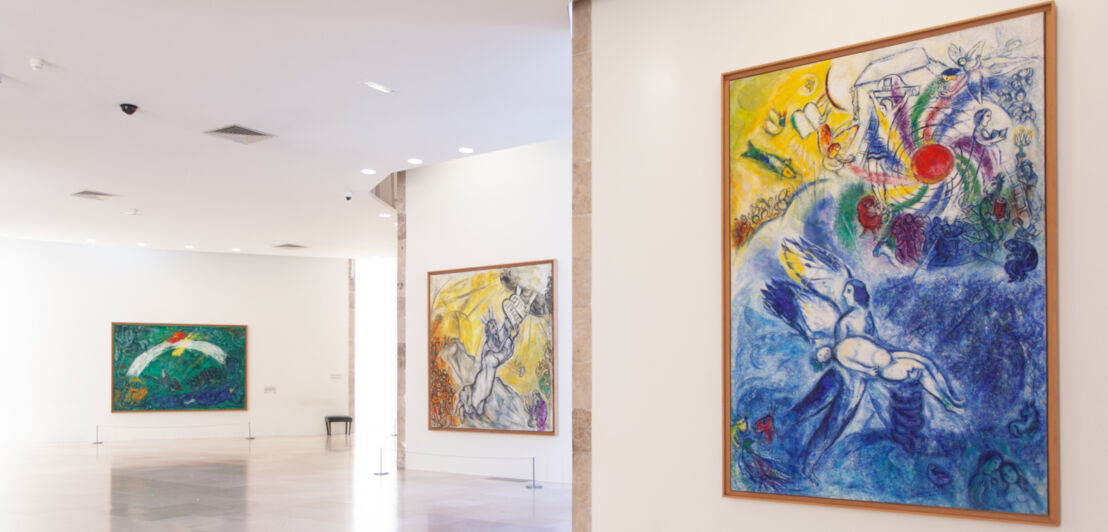 Innenaufnahme eines Ausstellungsraums in einem Museum, in dem Gemälde von Marc Chagall zu sehen sind