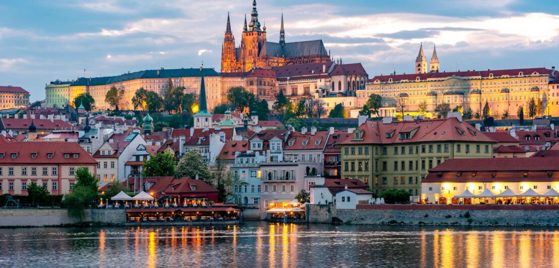 Stadtpanorama der Altstadt von Prag mit Burgkomplex auf einem Hügel, im Vordergrund Wasser