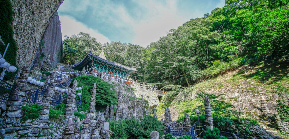 Skulpturengarten mit Steinpagoden in einer in einen Felsen gebauten buddhistischen Tempelanlage