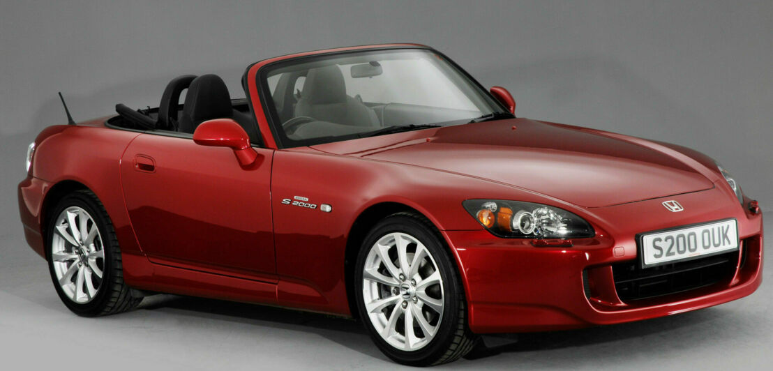 Studioaufnahme eines roten Honda S2000 vor grauem Hintergrund