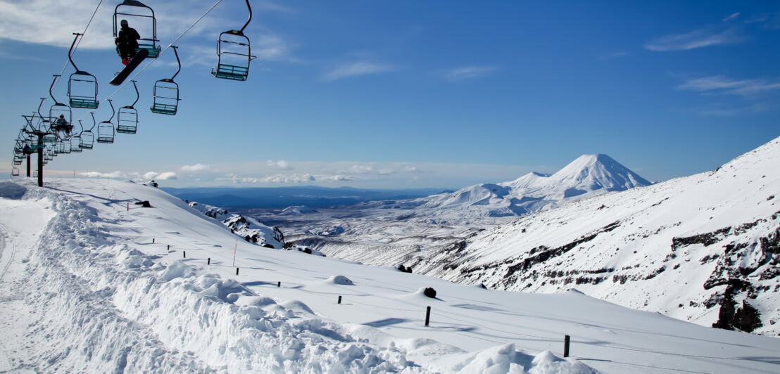 Ein Sessellift führt über eine schneebedeckte Berglandschaft