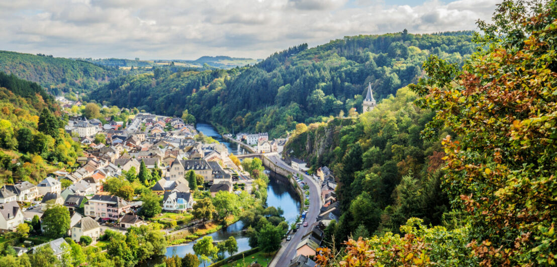 Ein Fluss fließt durch ein von Hügeln umgebenes Tal mit einer kleinen Stadt