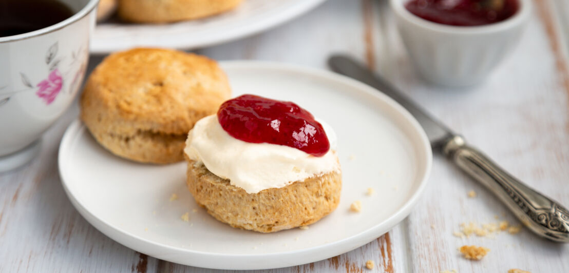 Nahaufnahme eines halbierten Scones mit Clotted Cream und Marmelade