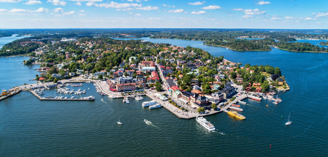 Ort mit Hafen auf einer Schäreninsel aus der Luftperspektive.