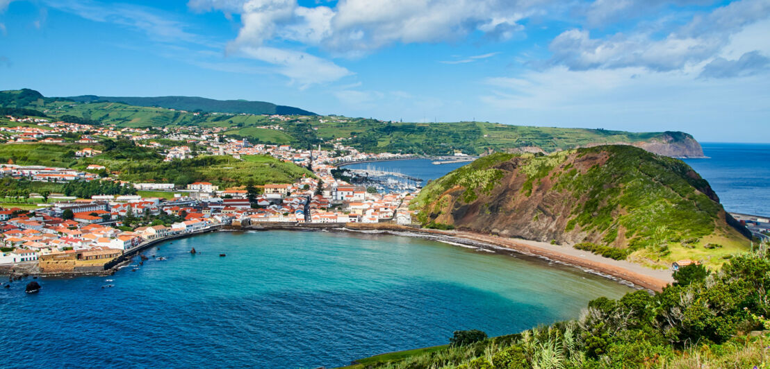 Mediterrane Stadt an einer Bucht mit Sandstrand.