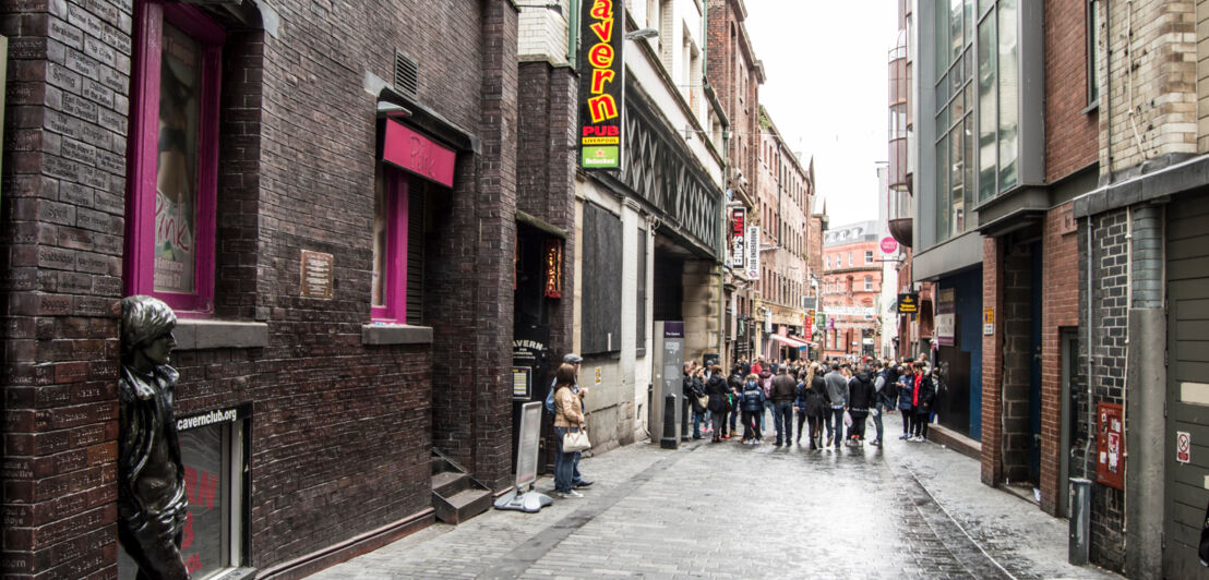 Straße mit Fassade und Schild des berühmten Cavern Club in Liverpool.