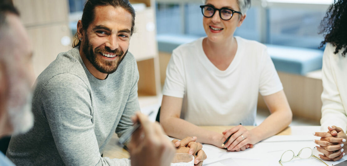 Happy design professionals having a discussion during a meeting in the office. Group of innovative businesspeople sharing creative ideas while working on a new project.