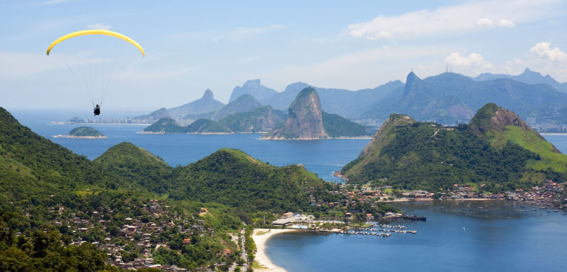 Ein Gleitschirmflieger schwebt über Rio de Janeiro.