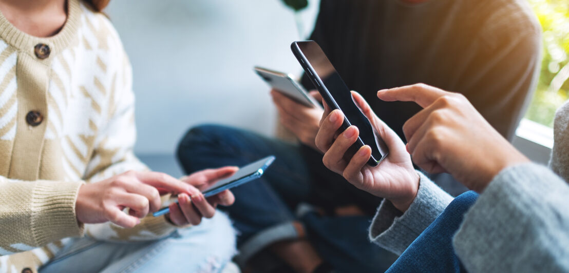 Group of young people using and looking at mobile phone together