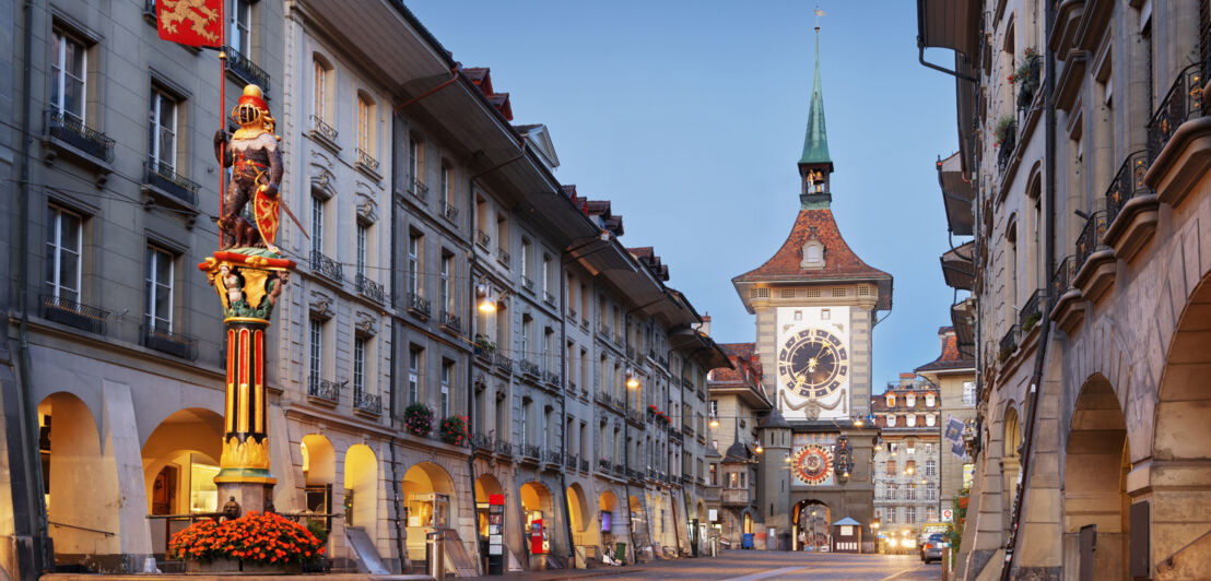 Straße in der Berner Altstadt mit dem Glockturm Zytglogge bei Dämmerung.