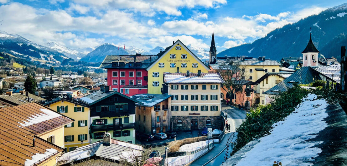 Altstadt von Kitzbühel, eingebettet in verschneite Berglandschaft.