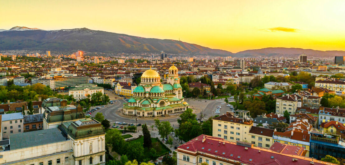 Stadtpanorama von Sofia mit orthodoxer Kathedrale im goldenen Licht bei Sonnenuntergang.