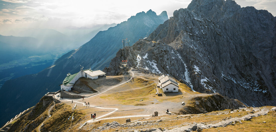 Bergstation vor Gipfelpanorama bei Sonnenschein.