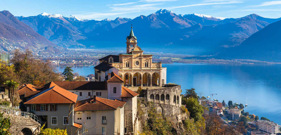 Kirche im schweizerischen Locarno mit Blick auf den Lago Maggiore und Berggipfel.