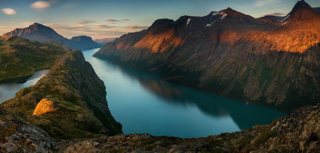 Bergkamm in Norwegen mit Wasser bei Sonnenuntergang.