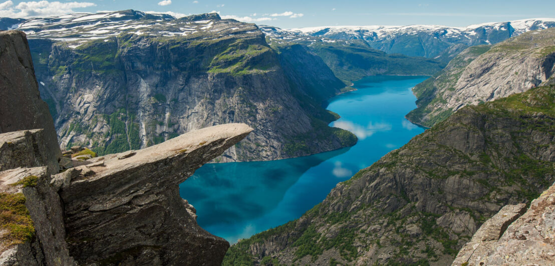 Felsvorsprung Trolltunga in Norwegen mit Fjord und Klippen im Hintergrund.