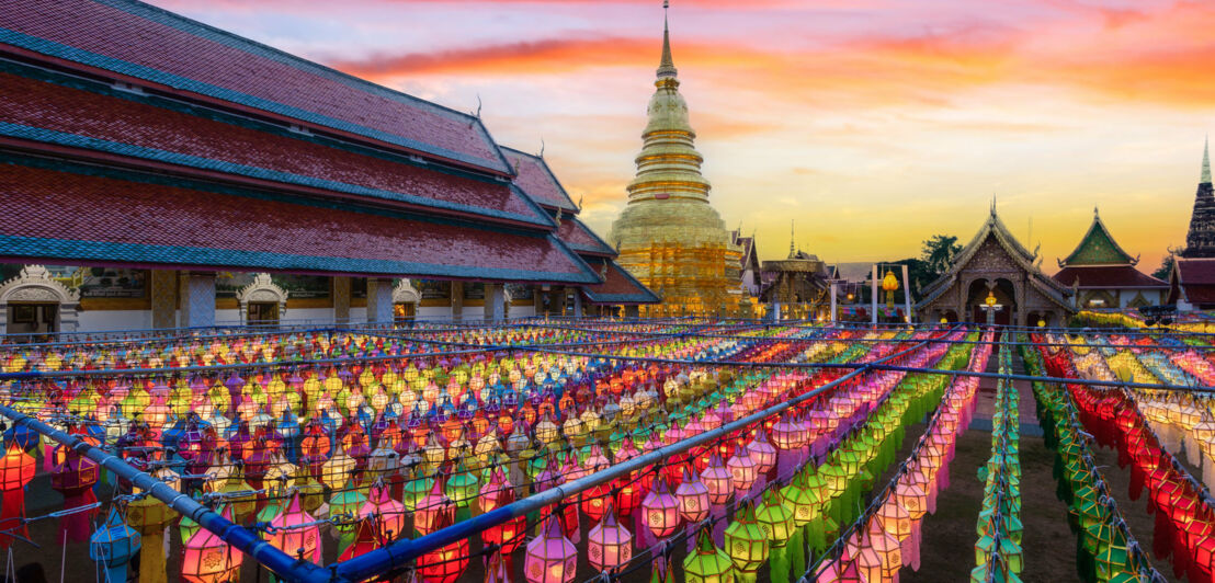 Tempelanlage im thailändischen Chiang Mai, die mit zahlreichen bunten Lampions dekoriert ist.