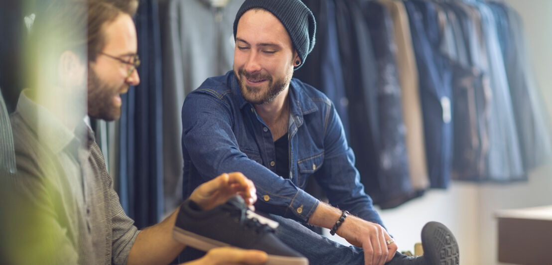 Ein Schuhverkäufer im Gespräch mit einem Kunden.