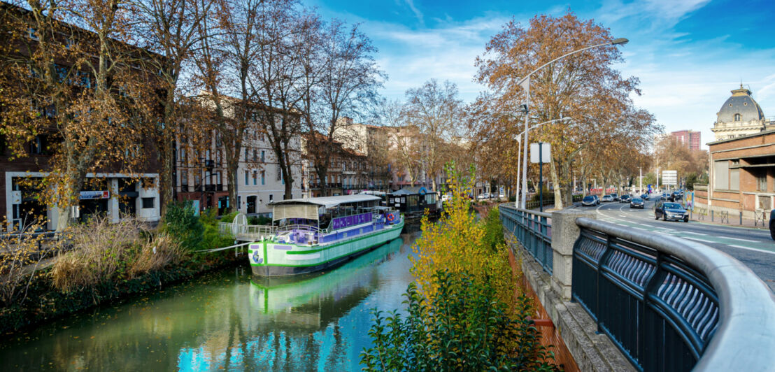 Ein Ausflugsboot auf einem Kanal in einer Stadt.