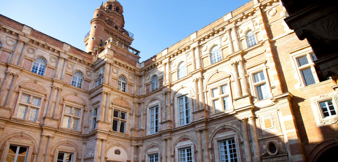 Hausfassade eines Stadtpalais in Renaissance-Architektur unter blauem Himmel.