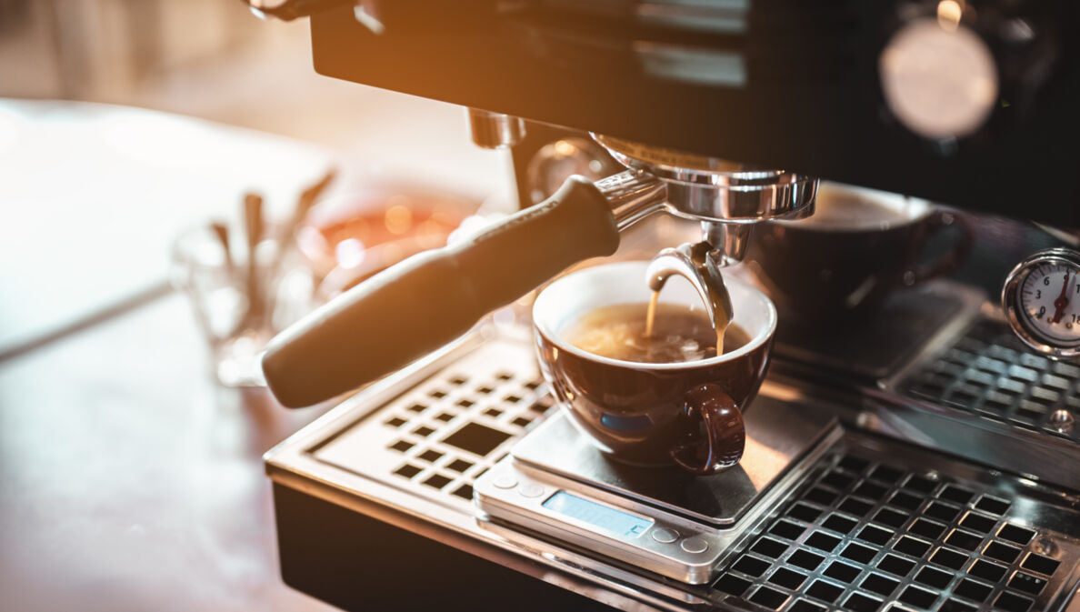 Espresso fließt aus einer Maschine in eine Tasse