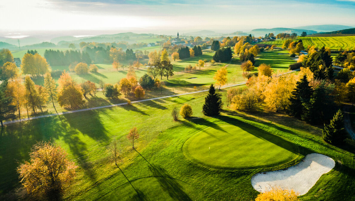 Blick auf Landschaft mit Golfplatz in der Abendsonne