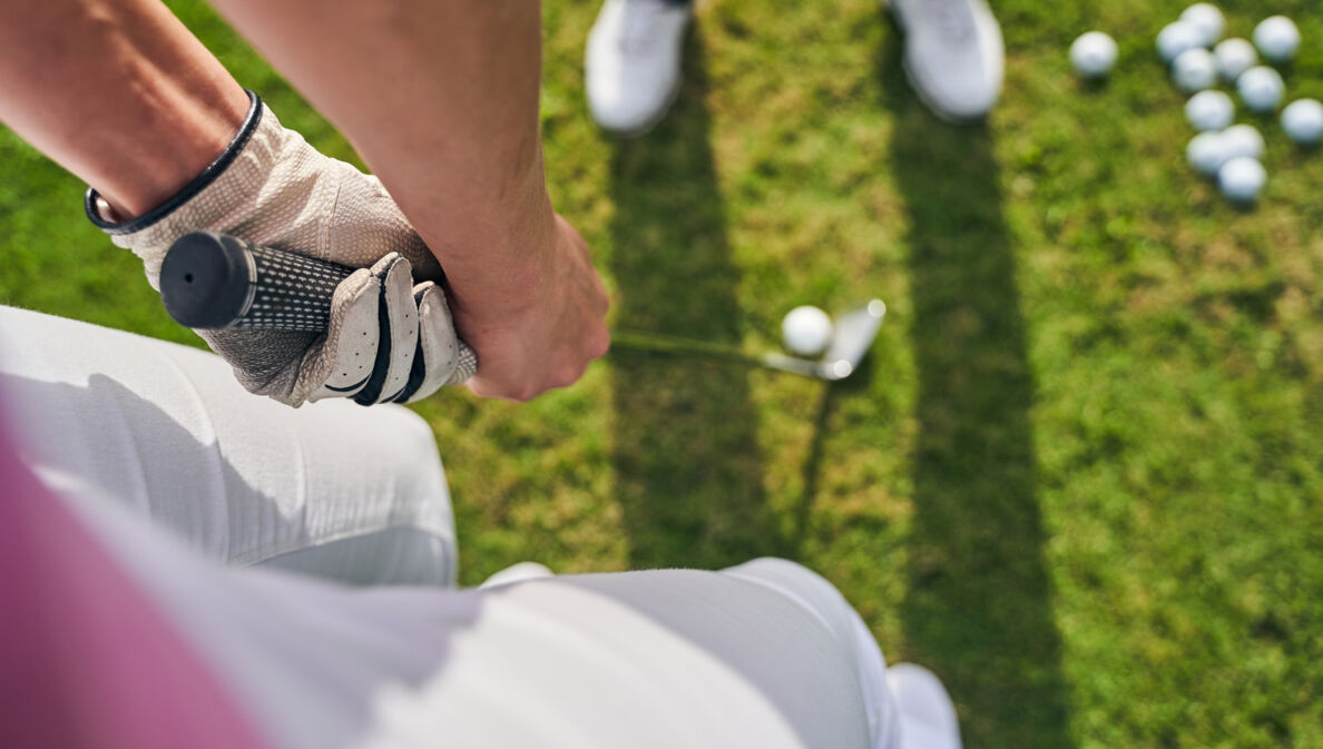 Blick von oben auf eine Person, die einen Golfschläger für den Abschwung hält