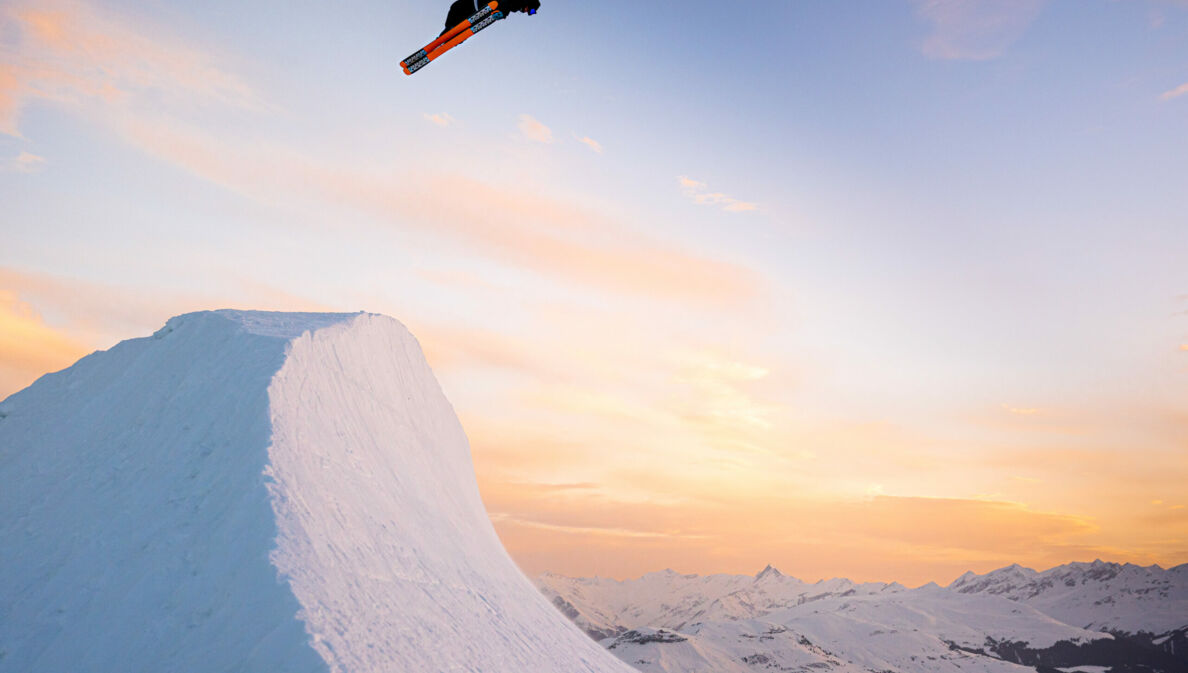 Eine Halfpipe bei Sonnenuntergang mit einem Snowboarder