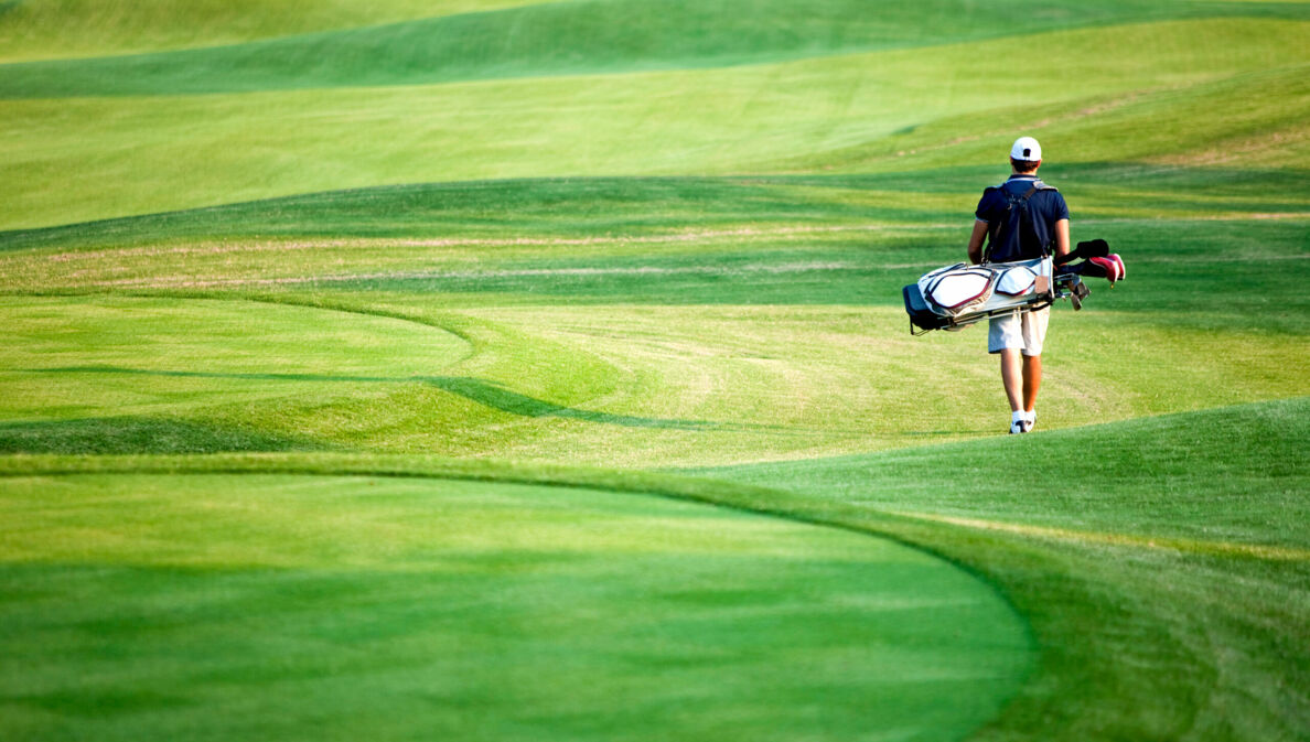 Golfspieler mit Equipment auf Golfplatz