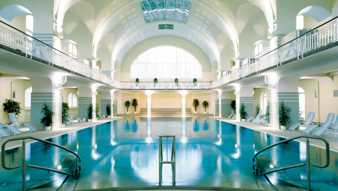 Großes Schwimmbecken in einer im Jugendstil erbauten Badeanstalt mit weißem Kuppeldach