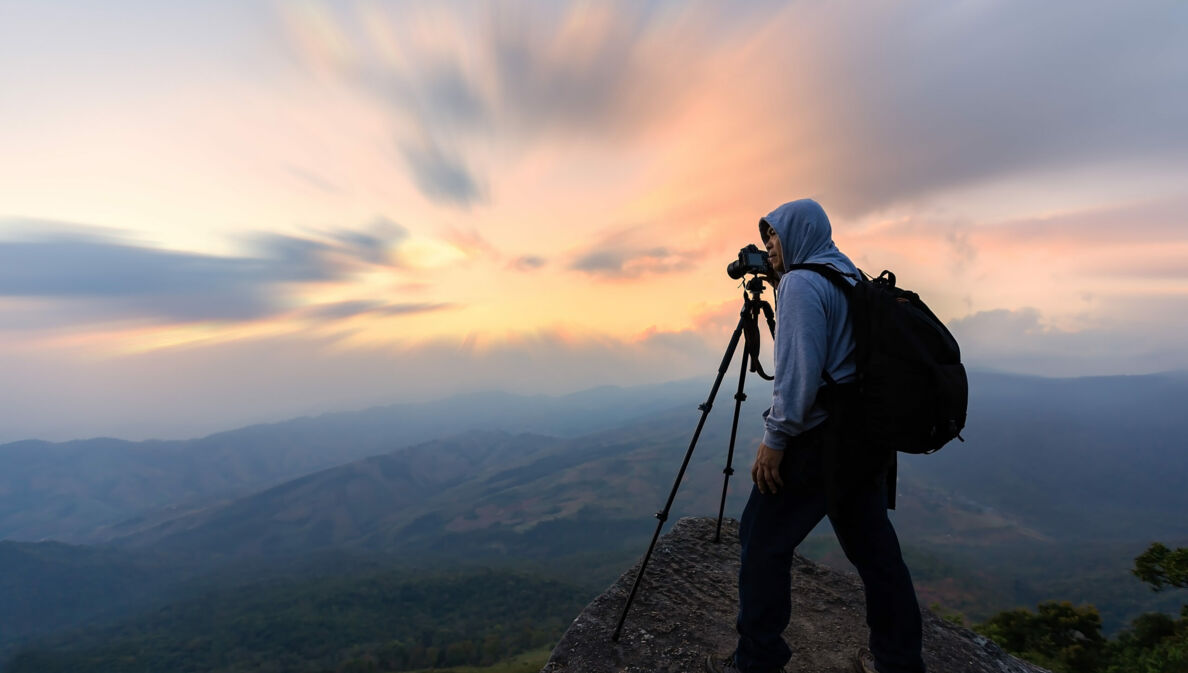 Ein Fotograf im morgendlichen Gebirge