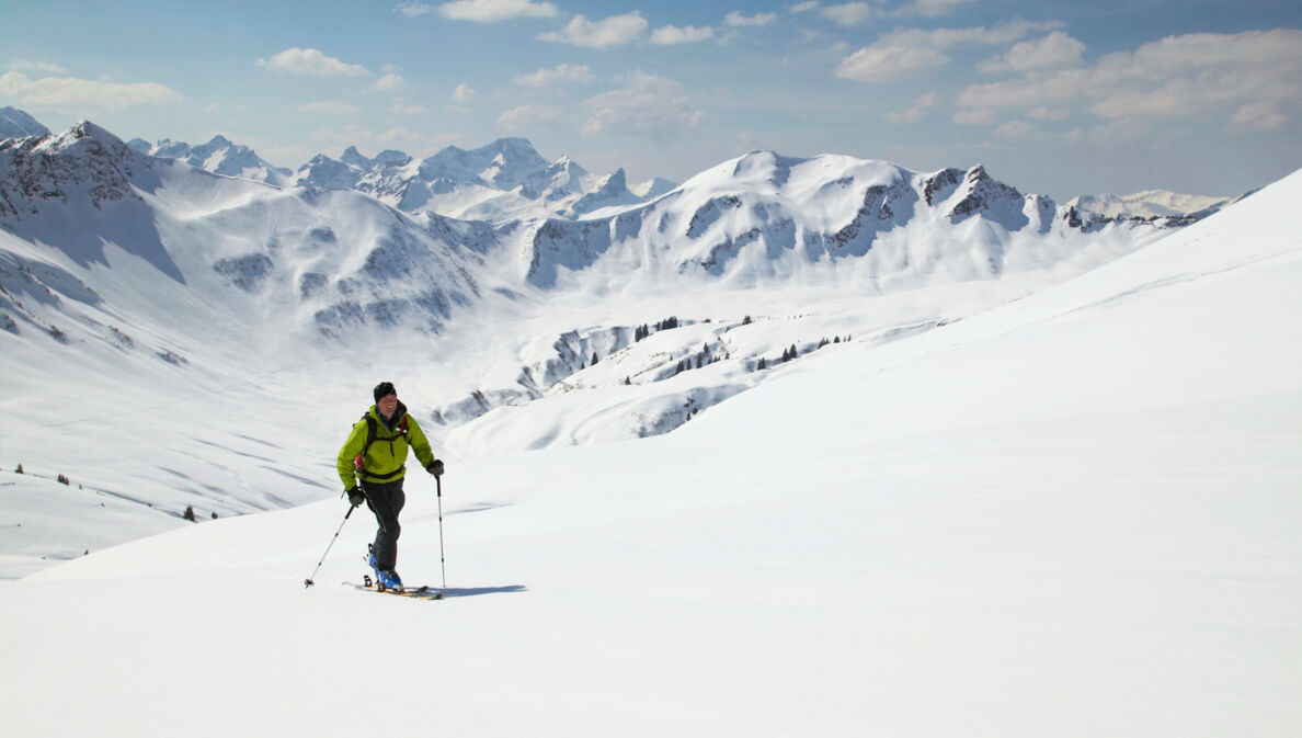 Ein Mann auf Ski in schneebedeckter Berglandschaft