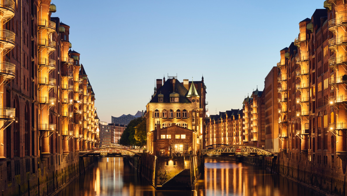 Die beleuchtete Hamburger Speicherstadt in der Abenddämmerung.