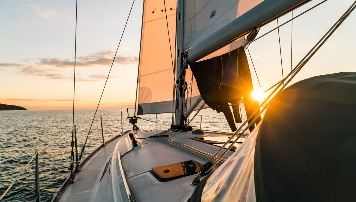 Segelboot, das in den Sonnenuntergang schippert