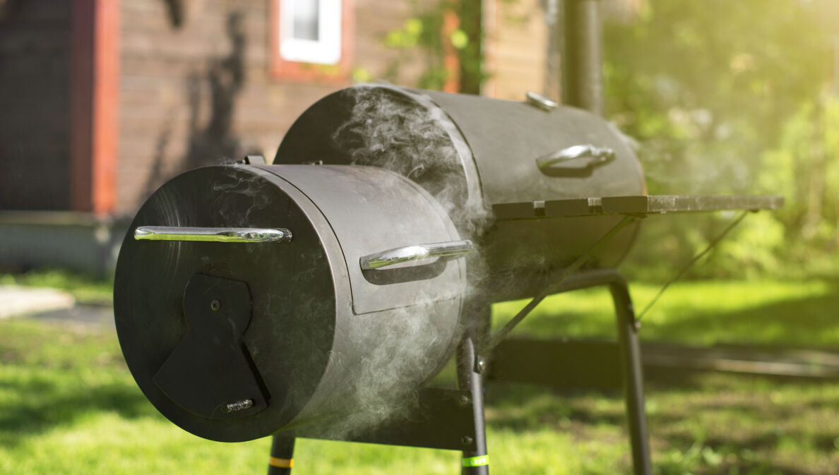 Ein qualmender Holzkohlegrill, in dem geräuchert wird