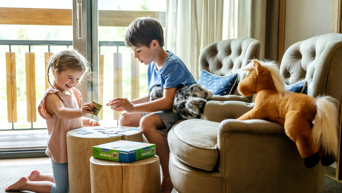 Zwei Kinder spielen in einem Hotelzimmer Memory