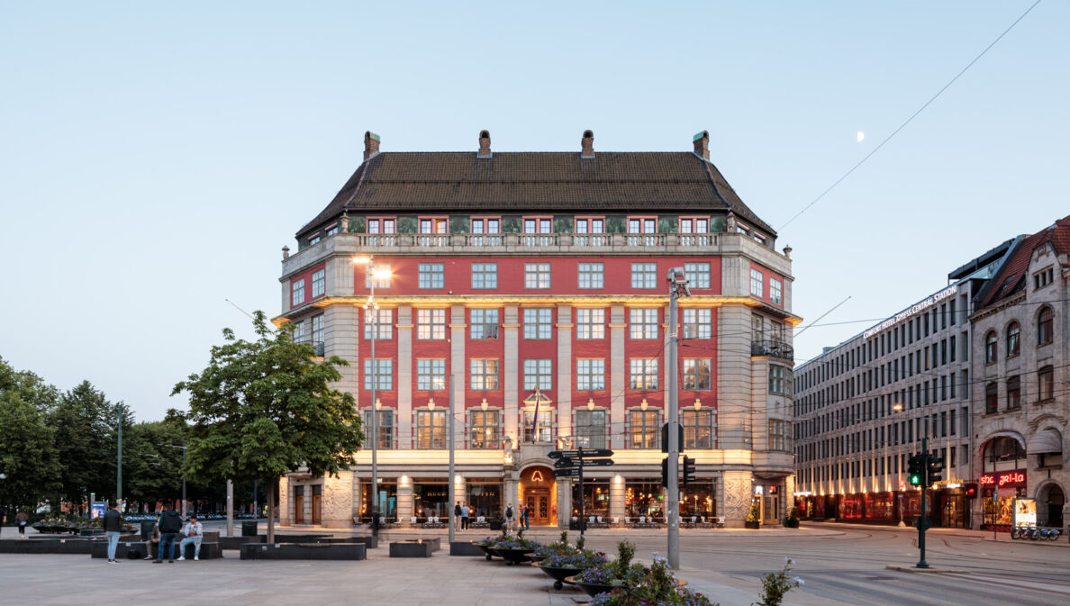 Prächtiges, beleuchtetes rotes Gebäude, davor ein großer Platz