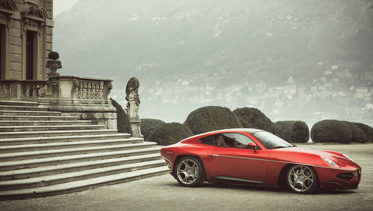 Ein rotes Auto vor der Treppe eines herrschaftlichen Hauses