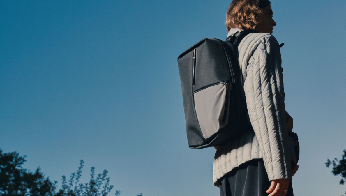 Von hinten fotografierte Person in Jacke und mit Rucksack des Labels côte&ciel