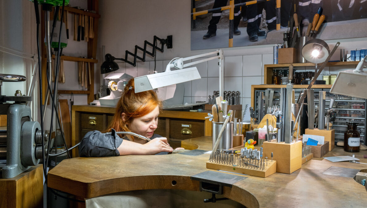 Eine Goldschmiedin im Atelier Jan Spille bei der Arbeit